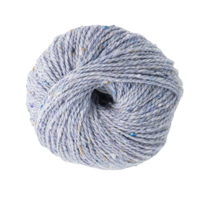 An opulent ball of light gray Jo Sharp Silkroad Aran Tweed yarn by Kingfisher Yarn & Fibre, adorned with specks of blue and tan on a pristine white background.