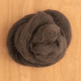 A carefully arranged swirl of RH Lindsay's Corriedale Wool Top, sold by the ounce, lies on a wooden surface, ideal for crafting enthusiasts eager to start their spinning yarn adventure.