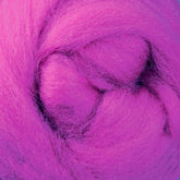 A close-up of bright pink New Zealand Corriedale wool fiber from Ashford Handicrafts Limited, tightly wound into a circular shape. The soft, fibrous texture showcases vibrant magenta hues—perfect for spinning and felting enthusiasts using this premium wool sold by the ounce.