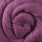 Close-up of a spiral-shaped texture featuring the Corriedale New Zealand Wool Fiber to Spin and Felt, sold by the ounce. This luxurious product from Ashford Handicrafts Limited showcases soft and fluffy purple fibers intertwined in a circular pattern, highlighting its gentle touch and vibrant appearance.