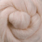 Close-up image of soft, fluffy Corriedale New Zealand Wool Fiber from Ashford Handicrafts Limited, tightly curled in a spiral pattern. The texture appears smooth and voluminous, resembling spun fibers or yarn, perfect for spinning or felting projects. Available by the ounce.