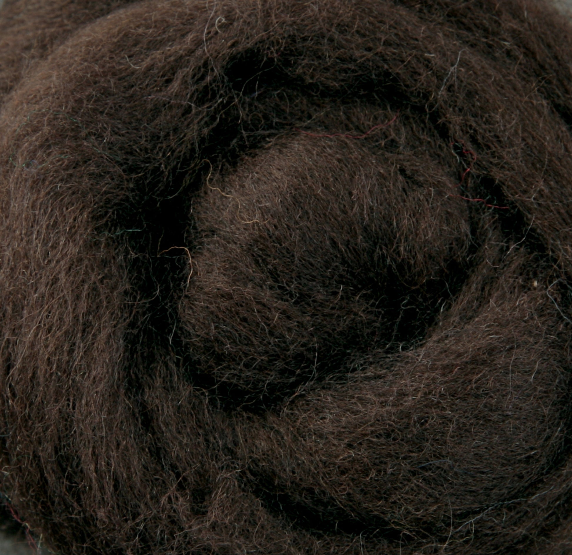 Close-up of a roll of dark brown Corriedale New Zealand wool fiber by Ashford Handicrafts Limited, perfect for felting projects, showcasing its soft, fluffy texture and spiral pattern. The dense fibers are slightly intertwined, highlighting natural color variations typical of this high-quality wool.