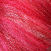 Close-up image of the Europa Wools Ltd Merino Silk Top Fiber showcasing its bright red, hairy or fuzzy texture with some white streaks. The vibrant strands, reminiscent of luxury blends like merino wool and silk, are densely packed, exhibiting a variety of red shades and giving a dynamic and lively appearance.