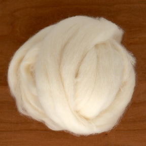 A luxuriously soft bundle of Yak Down Fiber, sold by the ounce, from Europa Wools Ltd is placed on a wooden surface. The fiber, fluffy and thick, appears ready for spinning into lofty yarn perfect for crafting.