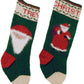 Two Yankee Knitter Designs Santa Christmas Stockings in green knit, each showcasing a distinct Santa Claus pattern. One stocking features a full Santa face, while the other shows Santa holding a sack of toys. Both stockings are accented with red heels and toes and topped with an upper trim that includes Christmas-themed text.