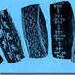 A close-up image showcasing four intricately woven Double Knit Headbands, crafted by Nancy Lindberg, each featuring unique white or light-colored geometric or floral designs on a dark background. These beautifully patterned headbands make an ideal gift.