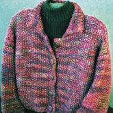 The Simply Seed Jacket by Bryson Distributing, Inc. is displayed over a black turtleneck base. This multicolored seed stitch knit cardigan highlights a blend of pink, purple, and green hues and features five visible buttons down the front, complemented by a high collar.