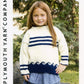 A young girl with long red hair is wearing an Encore Kid's Nautical Pullover from Plymouth Yarn Co, featuring navy blue horizontal stripes and a wave pattern along the bottom. She pairs it with a light blue skirt while standing outdoors in front of green trees. The text "Plymouth Yarn Co" is visible on the side.