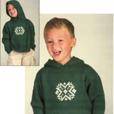 A young child is dressed in a dark green Plymouth Yarn Co. Child's Snowflake Hoodie, knitted from worsted weight yarn, with a white geometric design on the chest. The child is smiling and laughing against a plain, light-colored background. An inset shows a full-body view of the child, also smiling, with hands in pockets.