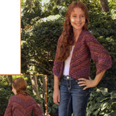 A girl with long red hair stands fashionably in a garden, showcasing a purple knit Child's Kimono Pattern by Plymouth Yarn Co, paired with a white top and jeans. She smiles with one hand on her hip. An inset highlights the back design of the kimono pattern. Bushes and trees create the scenic background.