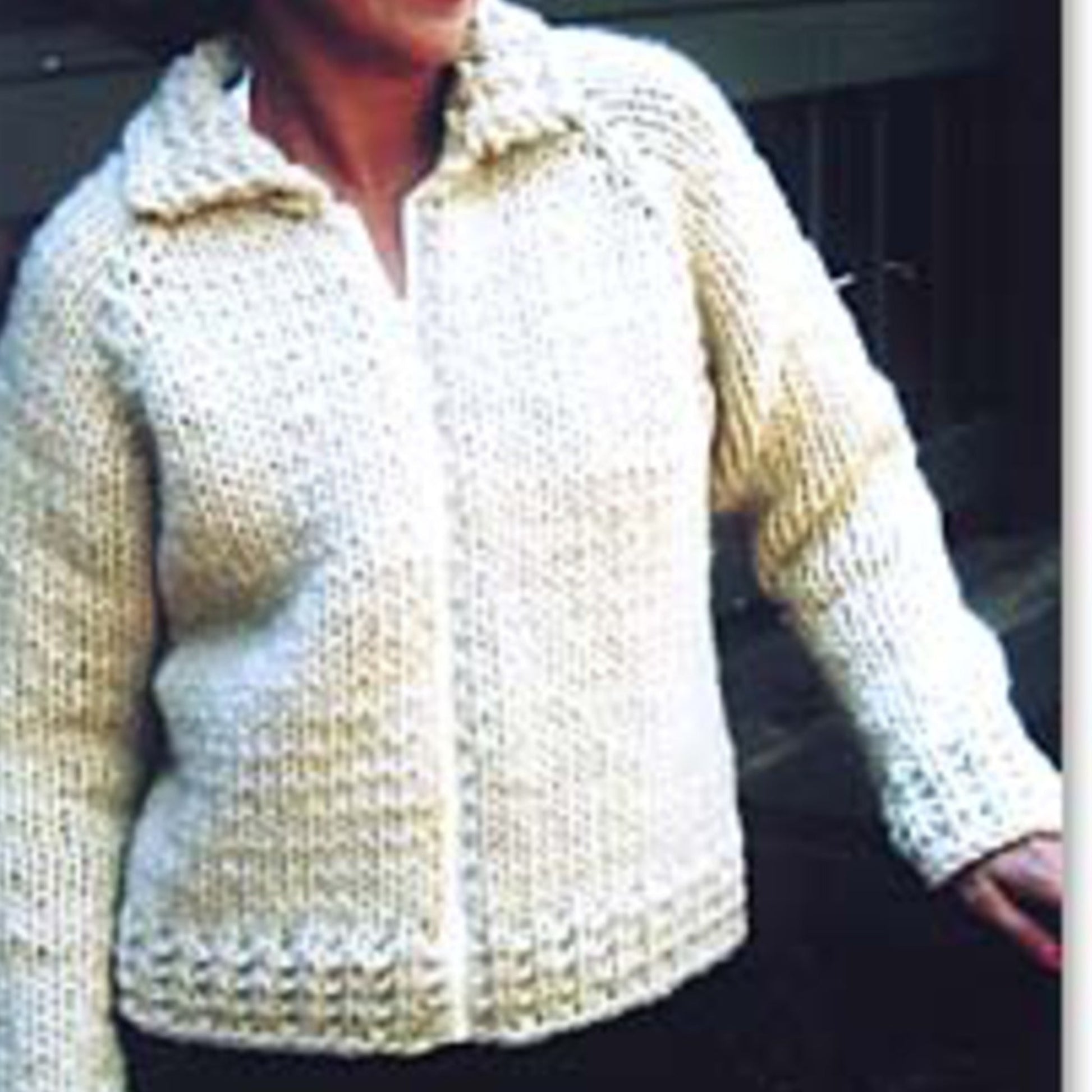 A person is wearing a cream-colored Weekend Neck Down Jacket from Bryson Distributing, Inc. The jacket features a textured pattern and gives off a handmade appearance. The individual is slightly turned to one side, with their face not fully visible against a blurred and indistinct background.