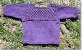 The Bryson Distributing, Inc. Fisherman T-Shirt Pullover Sweater for Baby Pattern is a delightful knitted infant sweater in purple, showcasing a textured chest design and shoulder button details. Laid flat on a grassy background, it exudes an adorable fisherman style.