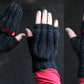 Three images showcase a pair of black, fingerless knit gloves from Lisa's Knits, adorned with three large red buttons on the top. A person with light skin and gray nail polish models these winter accessories, displaying the front, palm, and side views against a dark background. The product is named "Fingerless Gloves and Mitts 5 sts/1".