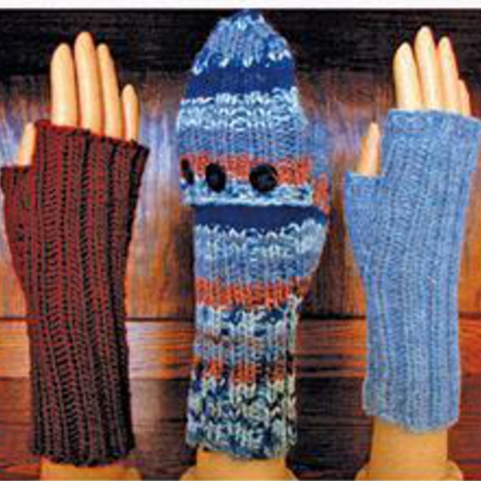 Three hands are displayed, each showcasing unique winter accessories from Lisa's Knits' Fingerless Gloves and Mitts 5 sts/1" collection. The left hand wears a long, brown, fingerless glove. The middle hand sports a blue multi-colored puppet-like mitten with two black buttons. The right hand features a stylish blue fingerless glove made from self-patterning yarn.