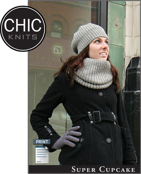 A woman wearing a grey knit hat with a ribbed band, a matching scarf, a black coat, and grey gloves is looking upwards and smiling while standing on a city sidewalk. Beside her is the "Chic Knits" logo with the label "Super Cupcake" below.