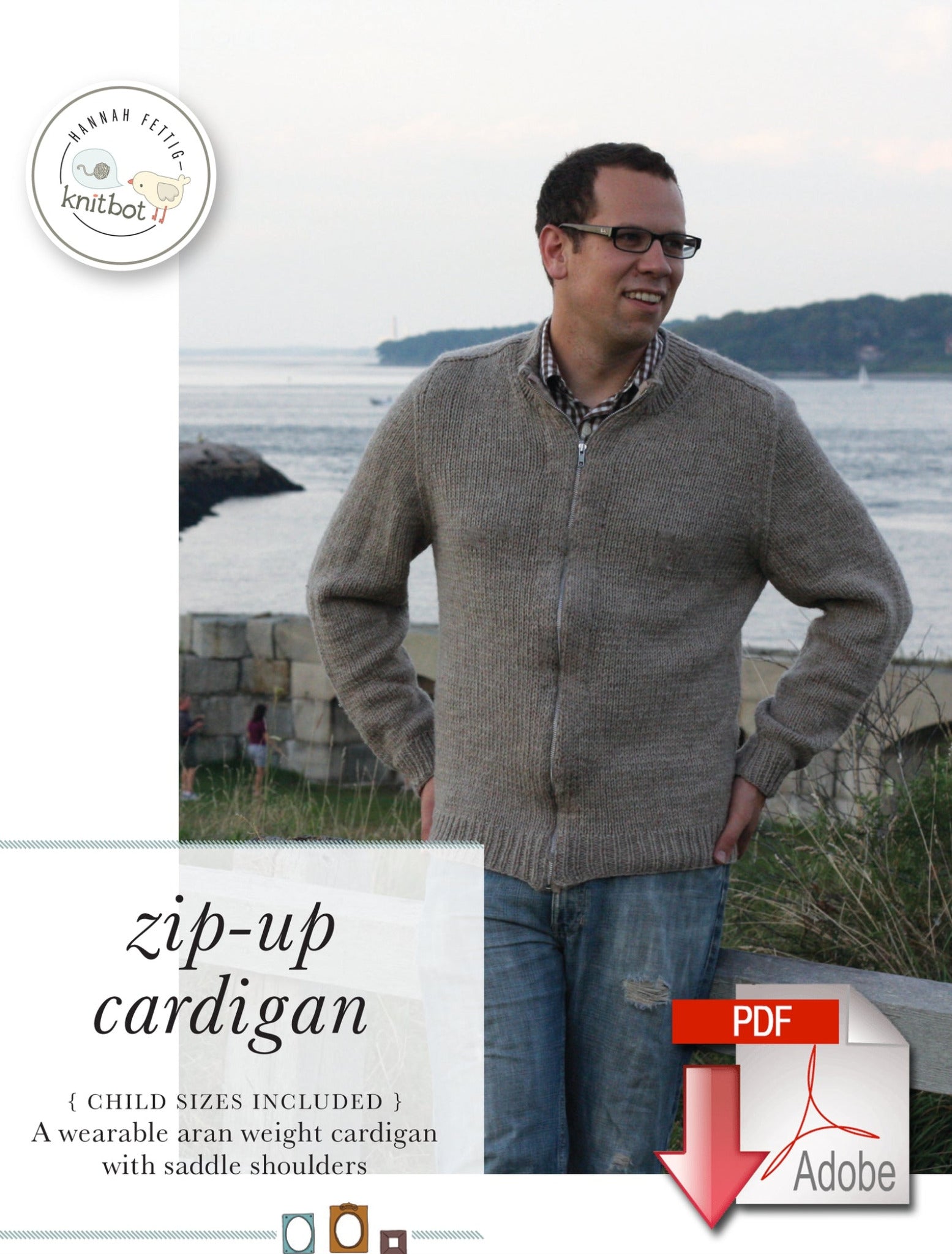 Near a body of water and rocky shore, a man wearing glasses stands outside in a grey Knitbot Zip-Up Cardigan by Never Not Knitting. The image text mentions that it's available in child sizes and describes it as an aran weight cardigan featuring saddle shoulders.