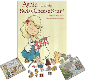 The image features the "Annie and the Swiss Cheese Scarf: Deluxe Gift Set" by Never Not Knitting, authored by Alana Dakos and illustrated by Neesha Hudson. Surrounding the gift set are related items including a children's puzzle, paper dolls, and various cut-out accessories like clothing and tools.