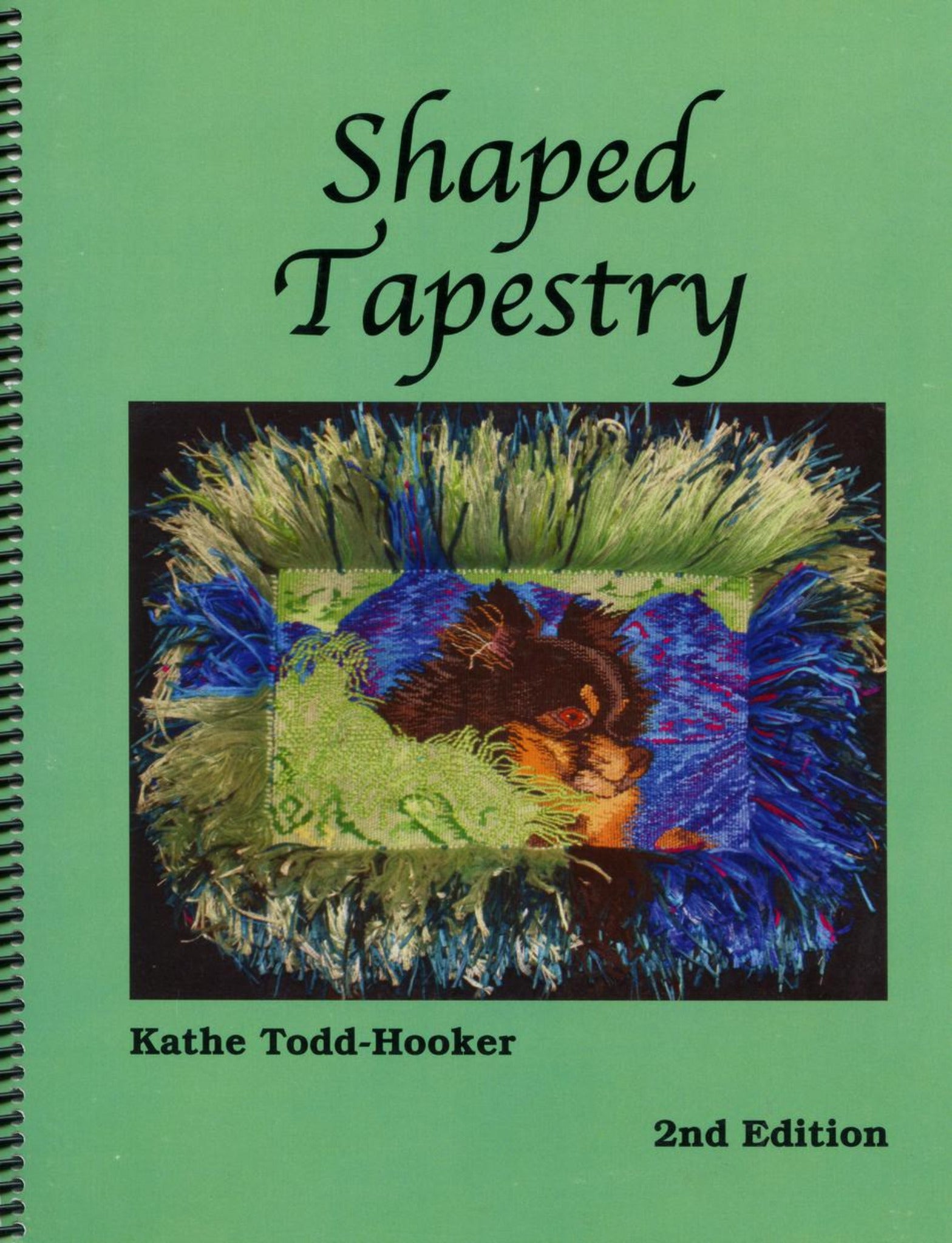 Cover of the book "Shaped Tapestry 2nd Edition" by Kathe Todd-Hooker, published by Fine Fiber Press. The cover is green and showcases an intricate non-rectangular tapestry with vibrant colors including blue, green, and black, featuring a detailed abstract design. The book is spiral-bound.