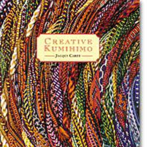 The image shows the book cover of "Creative Kumihimo" by Lacis. Featured prominently on the cover is a close-up photo of various colorful braided cords, showcasing intricate patterns and textures. Highlighting the Japanese braiding technique, the title is displayed in a red rectangle near the center.