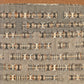 Cover of "On Weaving - New Expanded Edition" by Anni Albers, published by Ingram Content. The design features a textured, intricate weaving pattern in neutral tones, showcasing various textile fundamentals. The title is positioned at the top left in white text, set against a solid brown background, reflecting Bauhaus influences.