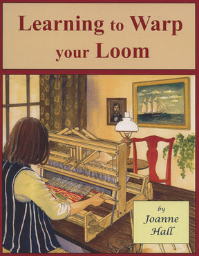 A book titled "Learning to Warp Your Loom" by Joanne Hall, published under the Glimakra brand, features a cover illustration of a person with long hair sitting at a loom, weaving with vibrant threads. In the background, there is a window, a painting of a ship, and a red chair. This book is an ideal choice for beginners eager to master the warping technique.