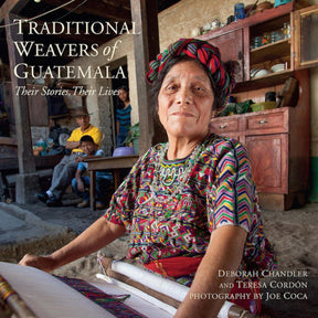 An elderly woman in traditional Guatemalan attire sits at a loom, meticulously crafting Maya textiles. She is in an artisan's workshop, with shelves filled with various items and a man sitting in the background. The book cover reads "Traditional Weavers of Guatemala: Their Stories, Their Lives," published by Ingram Content.