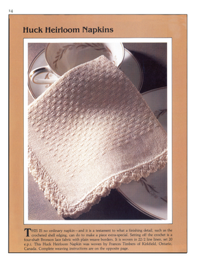 A close-up of a napkin from the Handwoven Design Collection #11, Heirloom Table Linens eBook (Printed version) by Long Thread Media, draped over a teacup and plate. The light-colored napkin features a crocheted border and is crafted as a four-shaft Bronson lace fabric with plain weave edges, woven in Ontario, Canada.