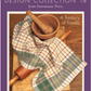 A woven towel featuring a plaid pattern in earthy tones is elegantly displayed over a rolling pin and a wooden mortar accompanied by a pestle, all set on a wooden surface. The cover text states: "Handwoven Design Collection #18, A Treasury of Towels eBook (Printed version) by Long Thread Media.