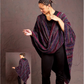 A person wearing a vibrant, striped shawl stands confidently against a textured background, with the shawl draping elegantly around their shoulders. The shawl is part of the Handwoven Design Collection #19 from Long Thread Media and pairs beautifully with black pants. An inset image reveals the back view of this exquisitely woven project.