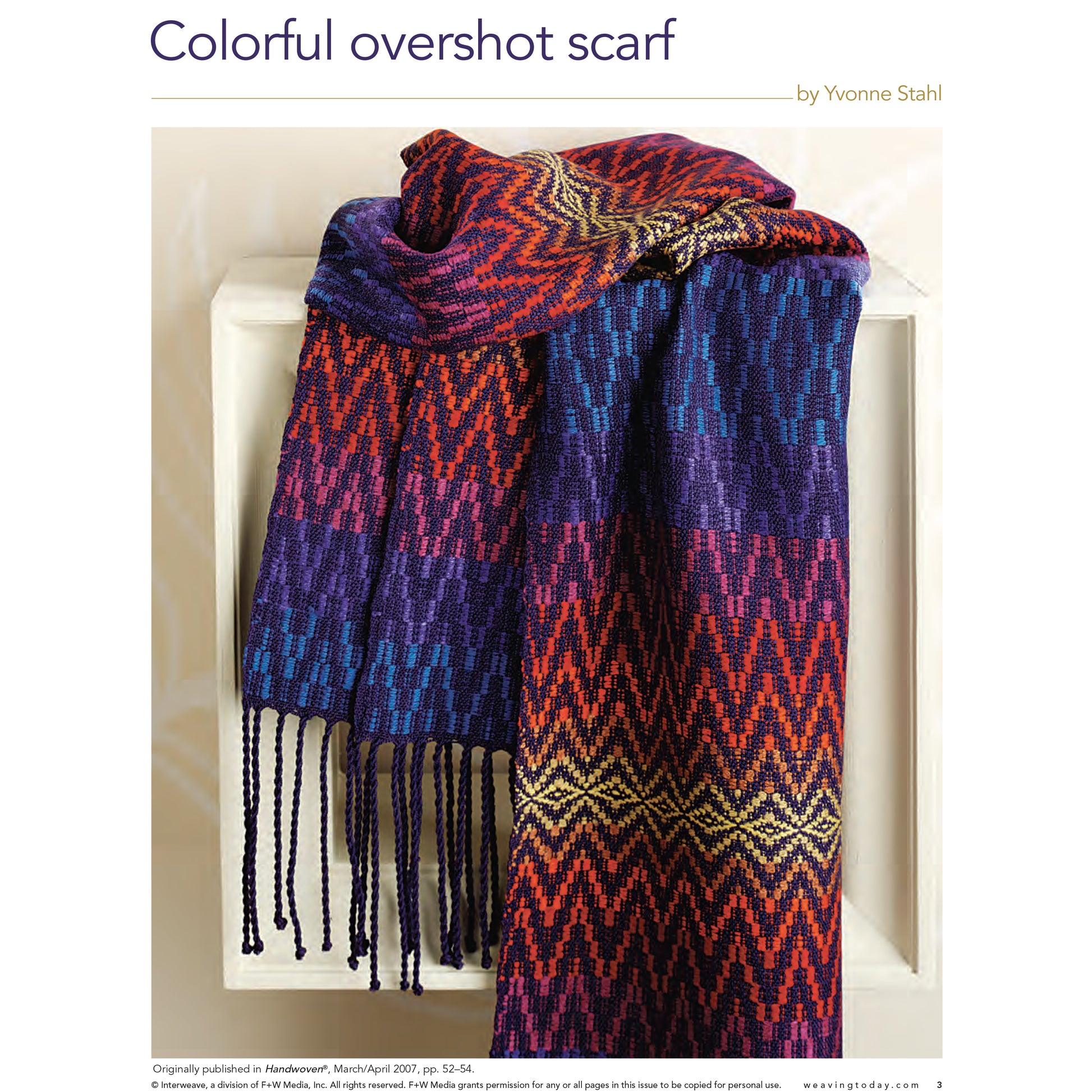 A scarf from the Handwoven Special Pattern Collection – 5 Gifts To Weave: eBook Printed Copy by Long Thread Media is draped over a white surface. The multicolored scarf showcases vibrant patterns in shades of purple, red, orange, blue, and yellow with intricate geometric designs. The fringed ends hang down, adding to its detailed texture.