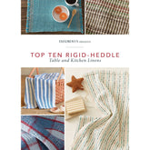 A magazine cover titled "Handwoven Presents: Top Ten Rigid-Heddle Table and Kitchen Linens: eBook Printed Copy" by Long Thread Media displays a variety of woven table and kitchen textiles, such as placemats, towels, and cloths, in an assortment of patterns and colors. A small starfish and a wooden soap dish are also featured.