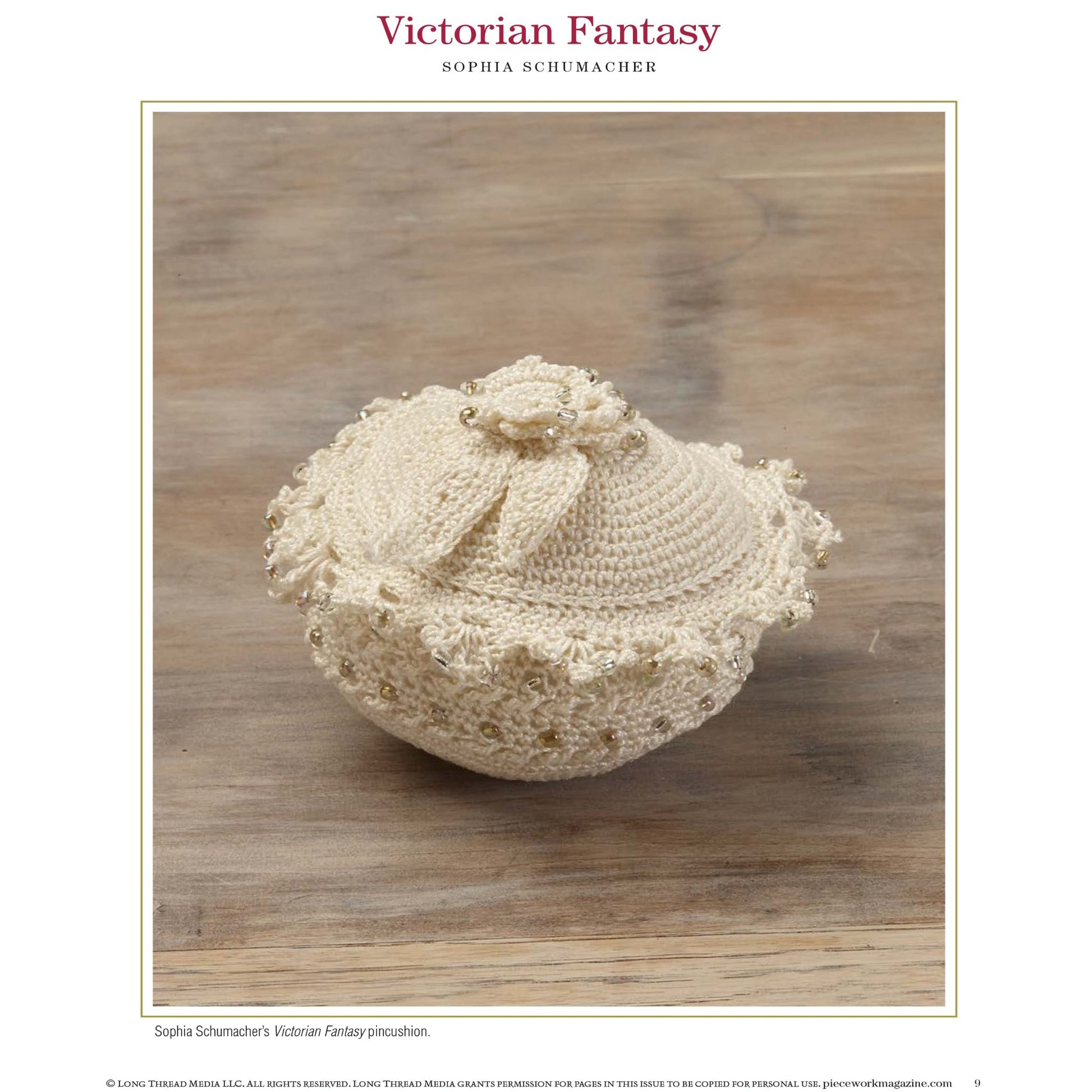 A decorative cream-colored pincushion, featuring intricate crochet work and a beaded trim, is displayed on a wooden surface. The pincushion's lid is adorned with a small crocheted bow. At the top, the text reads "PieceWork Presents: Pincushions 5 New Pincushion Designs to Bead, Crochet, Tat, Cross-Stitch, and Appliqué: eBook" by Long Thread Media.