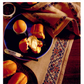 On a linen placemat adorned with the intricate designs from the Elegant Embroidery with 5 Beautiful Projects to Stitch eBook by Long Thread Media, a blue plate holding buttered bread rolls and a partly peeled boiled egg is placed. A knife lies close by on the dark wooden table.