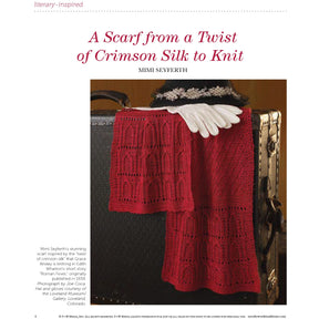 A red knit scarf featuring an intricate lace pattern is draped over the side of a vintage brown suitcase. A pair of white gloves rests on the top edge of the suitcase. The image caption reads, "'A Scarf from a Twist of Crimson Silk to Knit' by Mimi Seyferth from *PieceWork Presents: Literary-Inspired Projects to Knit, Crochet, Hook, and Cross-Stitch* – eBook printed copy by Long Thread Media.