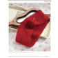 A copy of the printed edition of "Fall Into Red: 4 Knitting Projects for the Season" from Long Thread Media is placed on top of a hand mirror with a wooden handle. The mirror and eBook are set on a fabric background with a delicate floral pattern. The cover displays intricate knitting patterns and adds a pop of vibrant color.