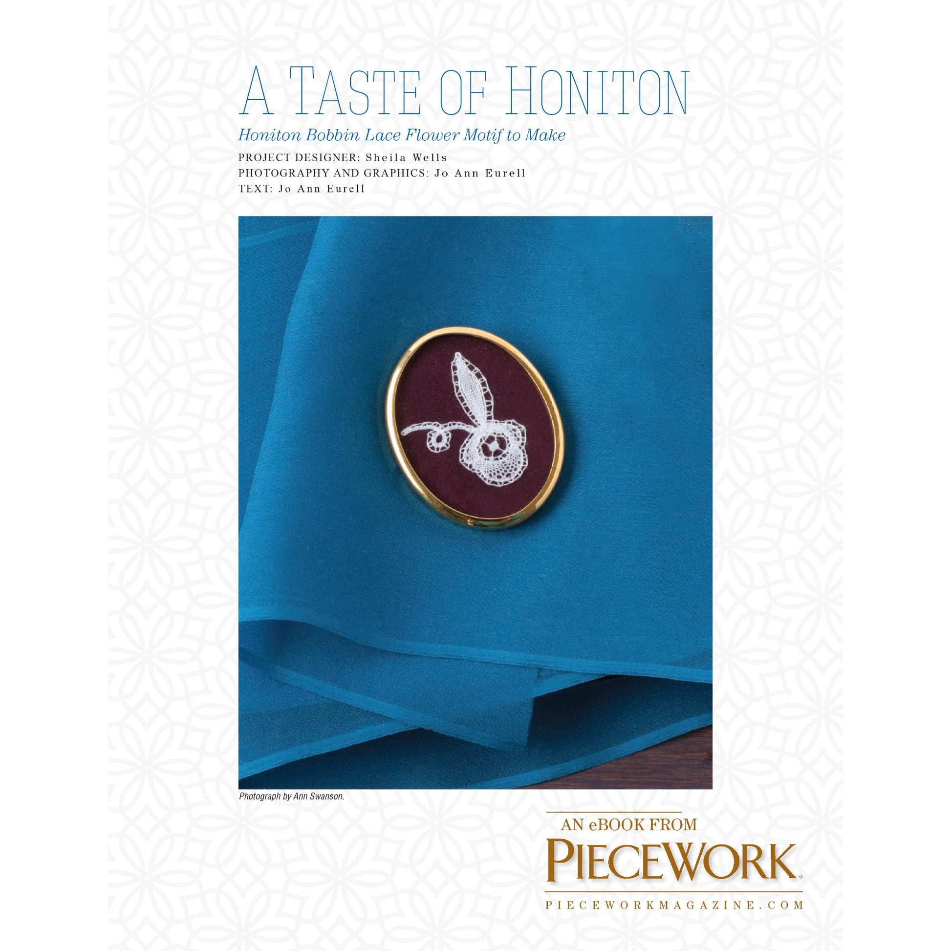 Cover image of "A Taste of Honiton: Honiton Bobbin Lace Flower Motif to Make – eBook printed copy" from Long Thread Media. It features a small, intricate Honiton bobbin lace flower motif set in an oval frame, placed on a bright blue cloth. The text mentions the project designer, Sheila Wills, and photographer, Jo Ann Eaverill.