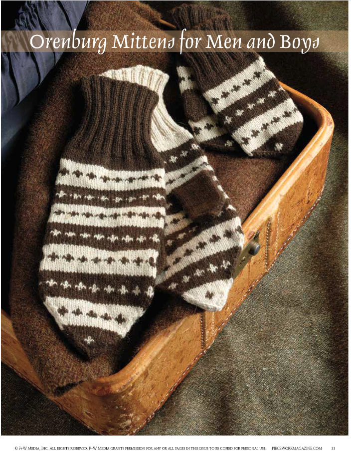 Displayed on a wooden surface is a pair of mittens with brown and white patterns, featuring stripes and geometric designs. These mittens are labeled "Knitting the North: 4 Traditional Mitten Patterns from Northern Europe – eBook printed copy" by Long Thread Media. The background is accented with dark brown fabric.