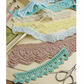 The eBook "A Lace Revival: 25 Vintage Edgings to Knit," from Long Thread Media, showcases vibrant 1940s crochet patterns like green wide leaf edging, yellow narrow leaf edging, pink lacy squares, and blue lacy stripes. Scissors and a crochet hook evoke memories of Weldon’s Practical Needlework projects.