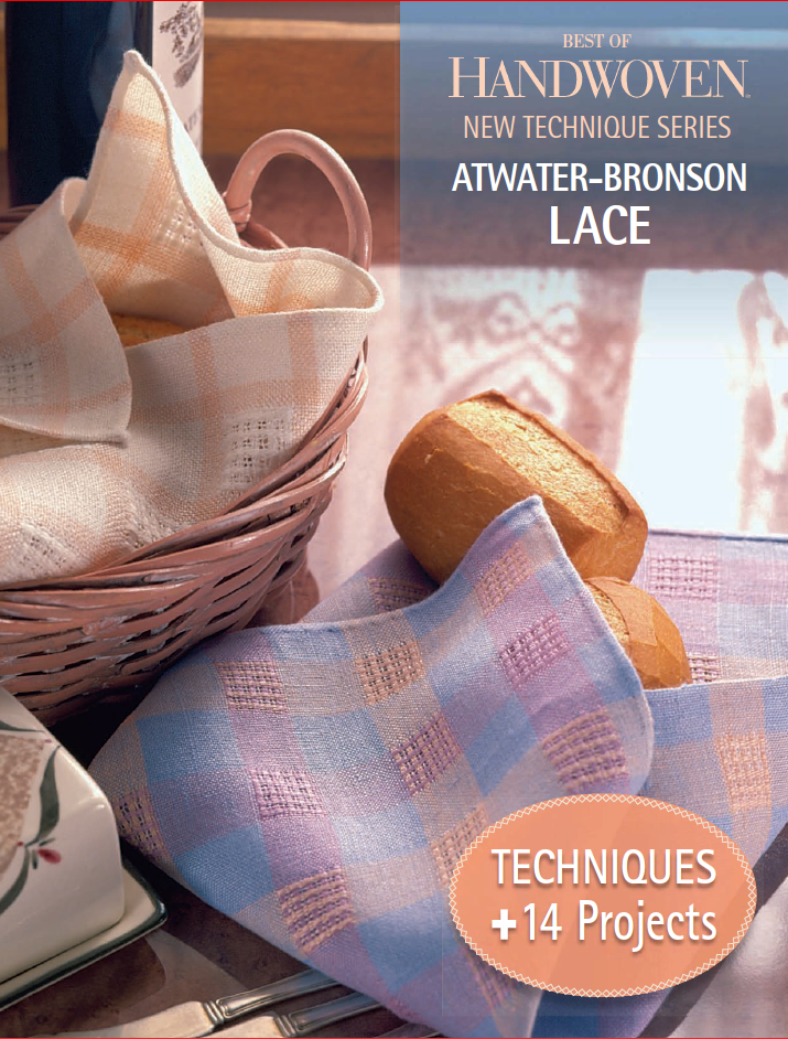 A woven basket with two bread rolls sits beside a napkin on the table. The book "Best of Handwoven New Technique Series: Atwater-Bronson Lace" by Long Thread Media is displayed, featuring "+14 Projects." Pastel checkered napkins beautifully complement the intricate lace designs.