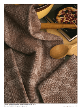 The "Best of Handwoven Technique Series: Twills on Four Shafts" printed eBook by Long Thread Media features a checkered brown and cream textile with intricate patterns, draped alongside a wooden spoon, rolling pin, bowl of dark liquid, and a cookbook with a pizza cover in the background.