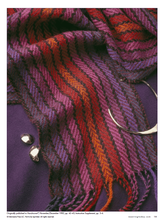 The "Best of Handwoven Technique Series: Twills on Four Shafts" eBook by Long Thread Media is printed, featured atop a deep purple fabric with a colorful wool scarf in red, purple, and orange shades. Two shiny silver beads and an open bangle add a touch of elegance.