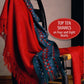 A vibrant red and blue fringed shawl is draped over a black wooden chair. The image is titled "Best of Handwoven," showcasing Long Thread Media's "Top Ten Shawls on Four and Eight Shafts" in a red oval on the right.