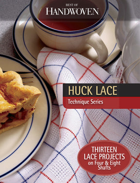 A table setting showcases a slice of pie on a plate, accompanied by a cup of tea and a teapot on a woven cloth adorned with blue and red stripes. This image graces the cover of "Best of Handwoven Technique Series: Huck Lace (Printed Version)" from Long Thread Media, highlighting thirteen lace projects.