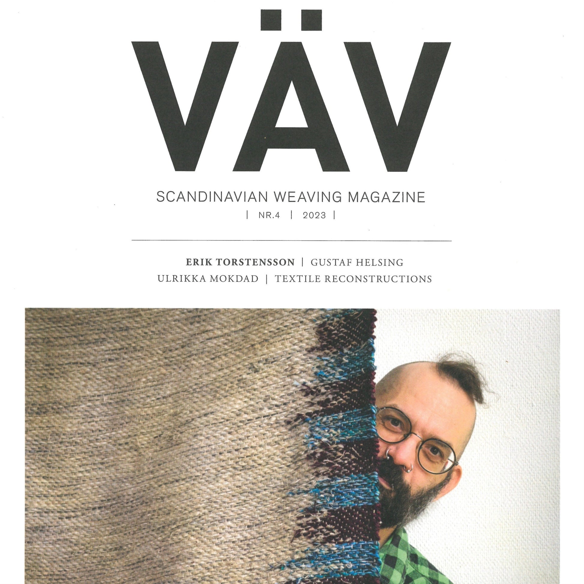 Cover of "VÄV Magasinet 4/23" from VÄV Magazine. A bearded person with glasses smiles while holding up woven textile art in shades of brown, blue, and green. This issue features articles like "Textile Material Speaks" by Erik Torstensson and includes contributions from Gustaf Helsing and Ulrikka Mokdad.