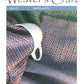 Cover of Plain Tabby Press's magazine, Weaver's Craft Issue 22: Twill M's and W's, featuring a white cup resting on folded, intricately woven fabric in shades of green, pink, and gray with a zigzag and diamond pattern. Headlines include "Designing Easy Treadlings," "Optimizing Floating Selvedges," and "Exploring M's and W's Twills in Weaving.