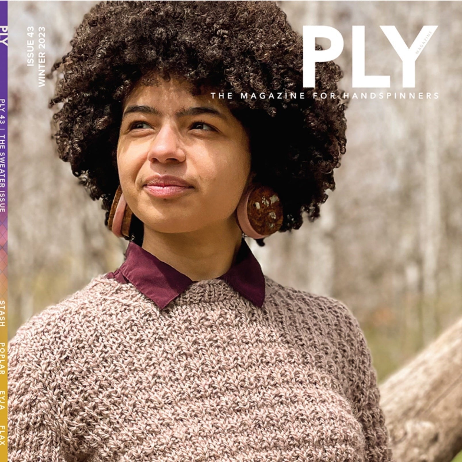 A person with curly hair gazes into the distance, wrapped in a textured sweater crafted from handspun yarn and adorned with large round earrings, set against a blurred forest backdrop. Text on the magazine cover reads "PLY Magazine: Issue 43, Winter 2023 - The Sweater.