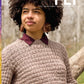 A person with curly hair, draped in a textured sweater and adorned with large earrings, gazes thoughtfully to the side in a wooded setting. Featured on the cover of PLY Magazine's Winter 2023 edition (Issue 43), the main headline highlights "handspun sweaters," epitomizing cozy creativity.