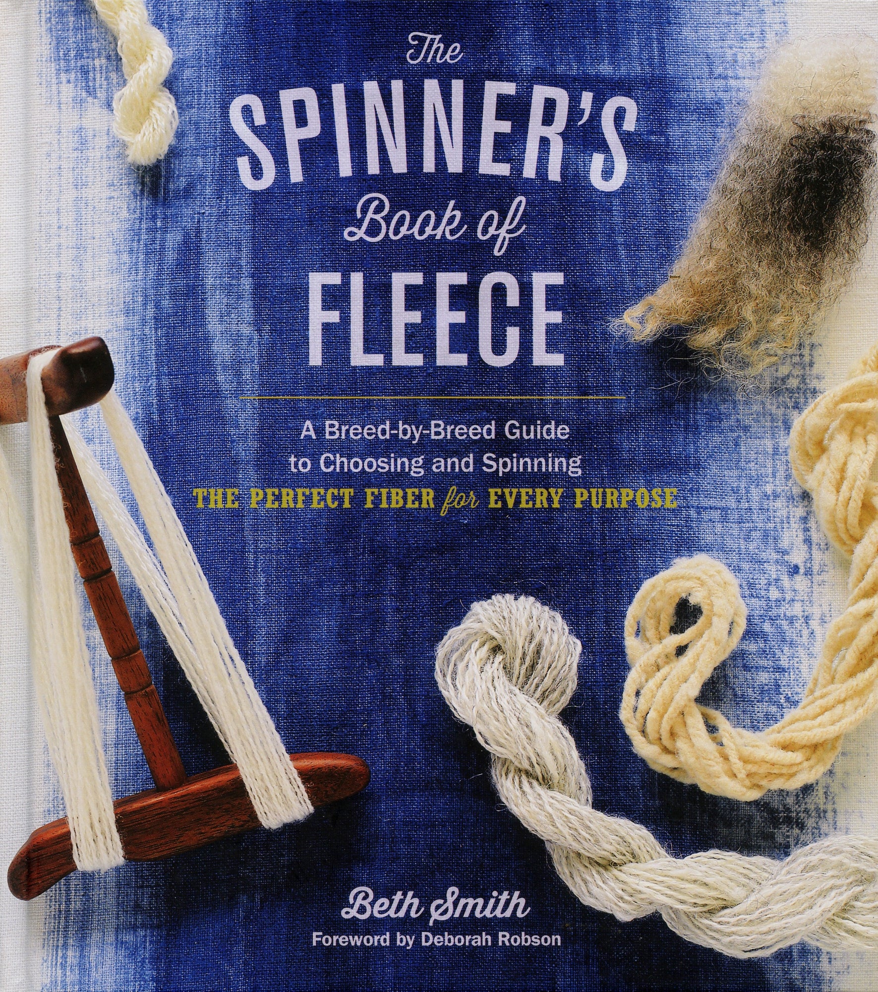 The cover of "The Spinner's Book of Fleece: A Breed-by-Breed Guide to Choosing and Spinning the Perfect Fiber for Every Purpose" by Workman Publishing - Storey features a wooden spinning tool surrounded by different types of spun fleece against a blue background. The text highlights it as an authoritative breed-by-breed guide to selecting and spinning fleece, detailing various sheep breeds and spinning techniques. It is authored by Beth Smith with a foreword by Deborah Robson.