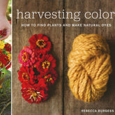 The cover of the book "Harvesting Color: How to Find Plants and Make Natural Dyes" by Rebecca Burgess, published by Workman Publishing - Storey, showcases a vibrant arrangement of red dye plants on the left, a skein of yellow yarn on the right, and a hand holding flowers in the background—ideal for enthusiasts who enjoy harvesting and dyeing.