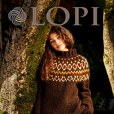 A woman with wavy hair is leaning against a tree trunk, wearing a dark brown knitted sweater featuring a colorful patterned yoke. The word "Lopi Book 37" is displayed at the top of the image. The background is dark and natural, highlighting the stylish design by Berroco, Inc.